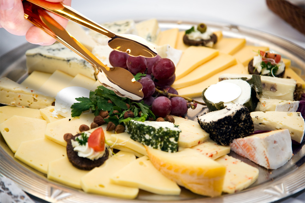 Gold tong at the cheese buffet